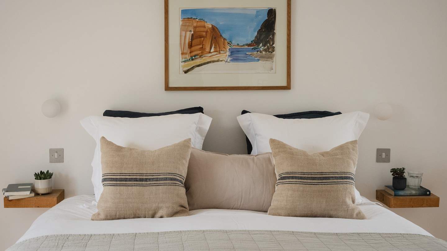 Tranquil tones adorn the second bedroom, where plump cushions and cosy throws embellish the sweet double bed