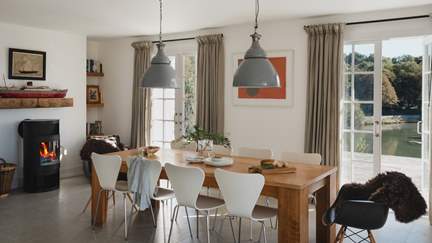 Two vintage leather armchairs flank the wood burner, perfect for cosy fireside scenes