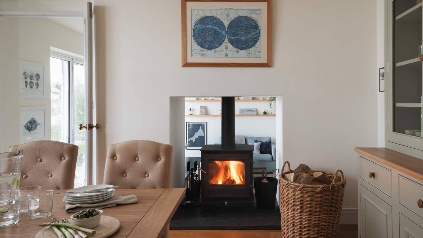 A dual-aspect wood burning stove sits between the formal and relaxed dining rooms