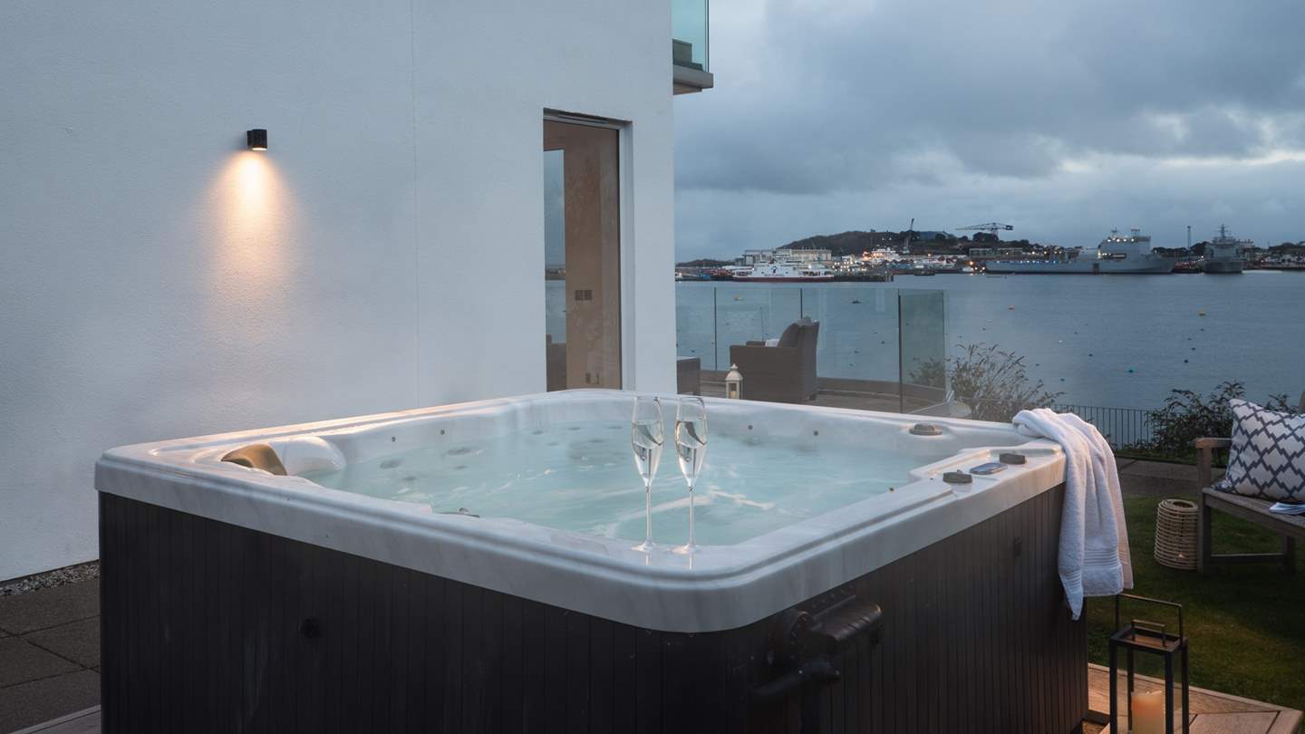 A bubbling hot tub is tucked to the side of the house, perfectly positioned to relax with a glass of bubbles whilst admiring the glorious seascape