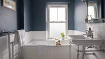 The first floor family bathroom, with deep blue walls and a beautiful bath