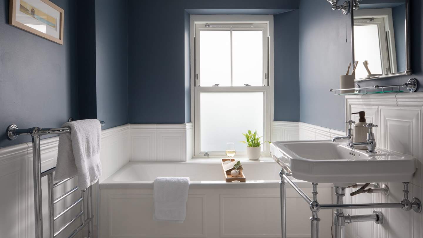 The first floor family bathroom, with deep blue walls and a beautiful bath