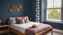 The oceanic theme continues through to the fourth bedroom, which is located on the first floor, with deep blue walls