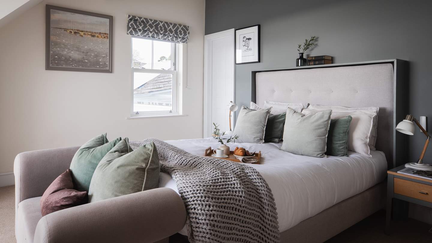 The master bedroom is located on the first floor, dressed in soft charcoal tones. 