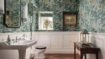 The elegant downstairs toilet is beautifully decorated with William Morris wallpaper
