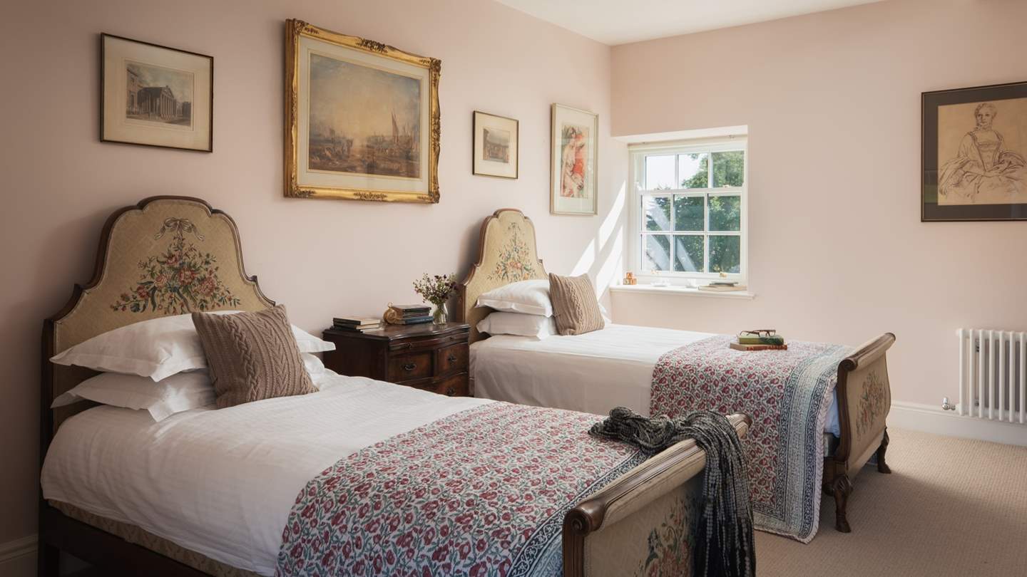The second bedroom is a sweet, spacious twin in soft shades of pink