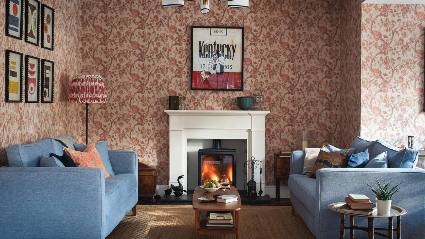 The heart of the home, the lounge is a picture of warmth with period inspired floral wallpaper and eclectic artwork