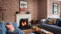 Exuding warmth in winter, a wood burning stove resides within a white fireplace and casts a cosy glow 