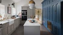 The exquisitely curated kitchen features a bespoke, floor-to-ceiling kitchen storage unit in blue 