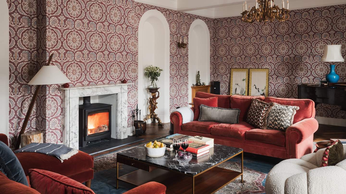 A music room awaits to be uncovered with two sumptious deep red sofas