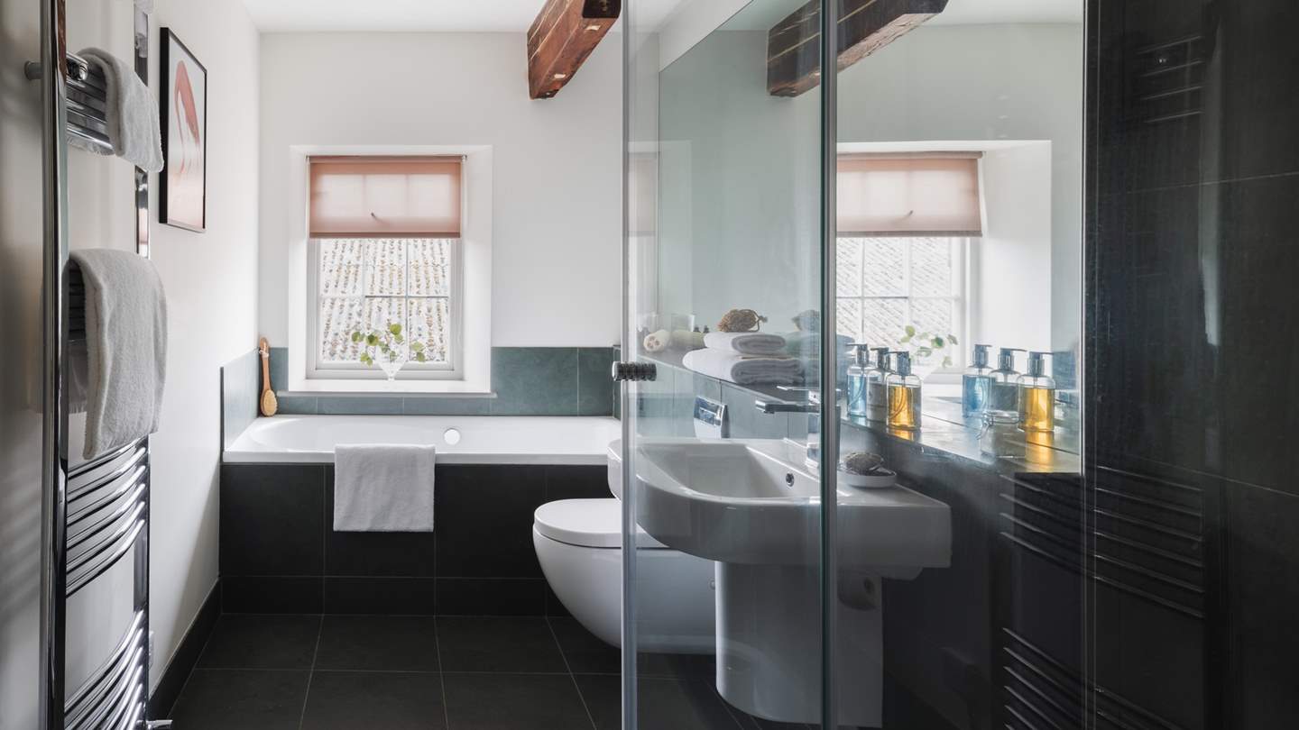 An adjoining ensuite in teal affords dreamy use of a walk-in shower and a separate bath