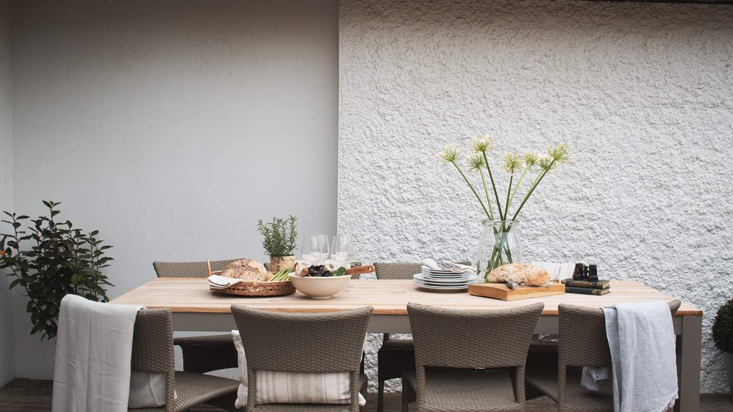 Meals alfresco await around the taupe-toned dining table...