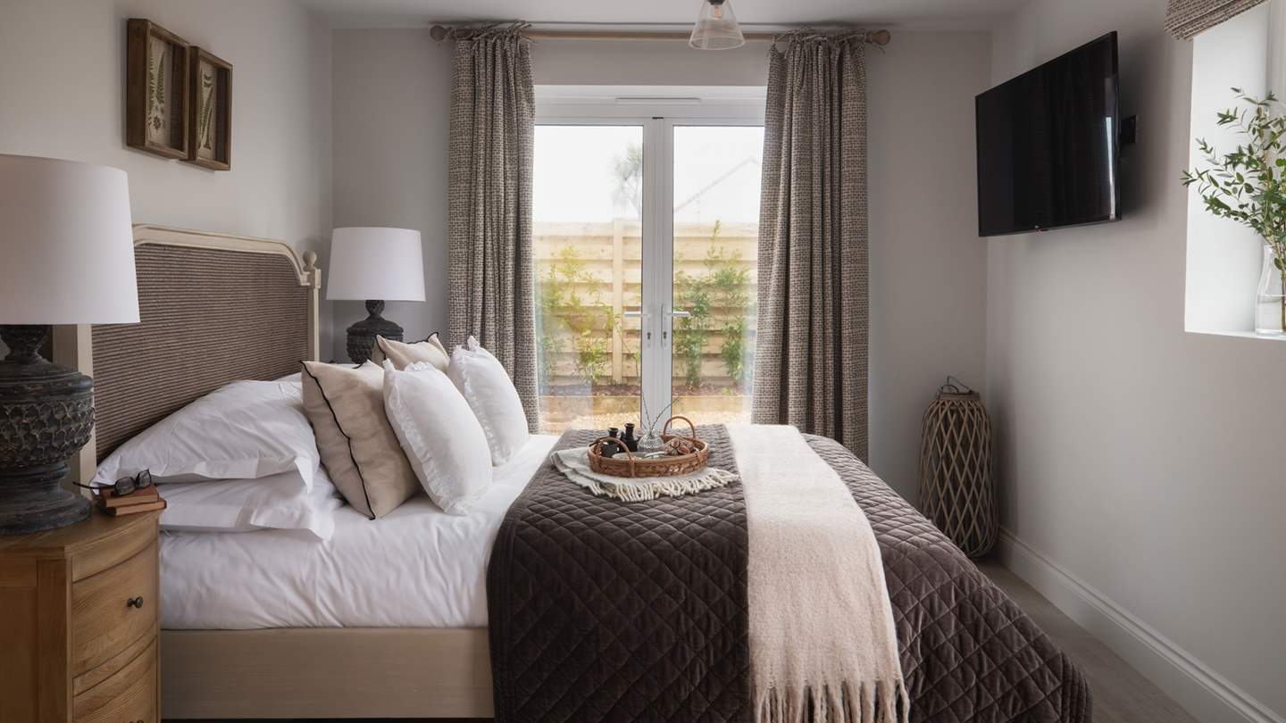 Tucked away on the ground floor you'll find a dreamy bedroom, with large doors leading to the garden...