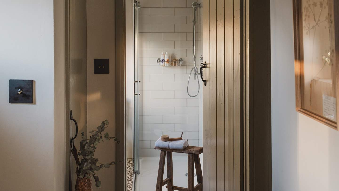 The carefully curated interiors continue into the family bathroom, with a large walk-in shower with a rainfall head and handheld attachment