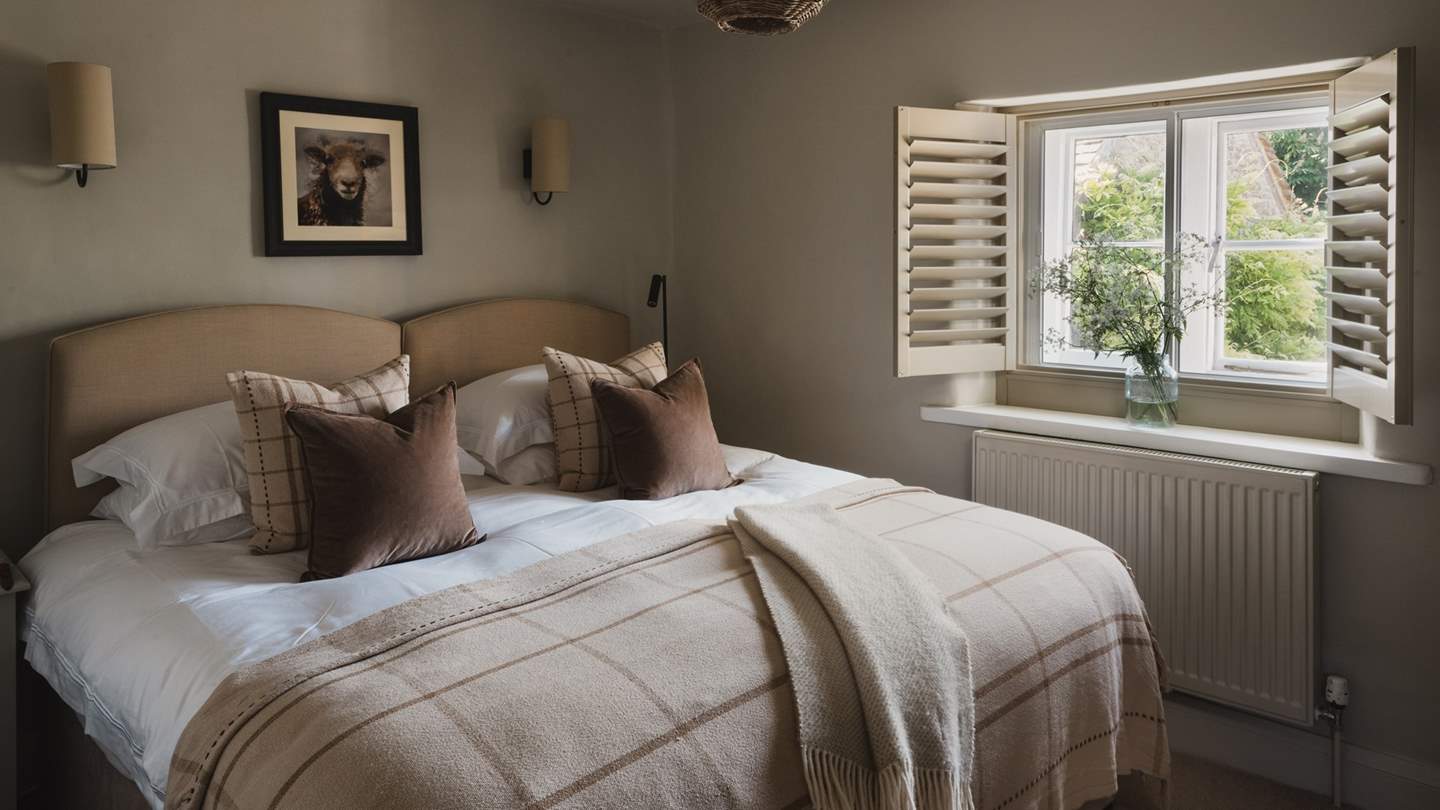Bedroom two has a plush fabric headboard which beautifully complement the harmonious oatmeal-hued interiors