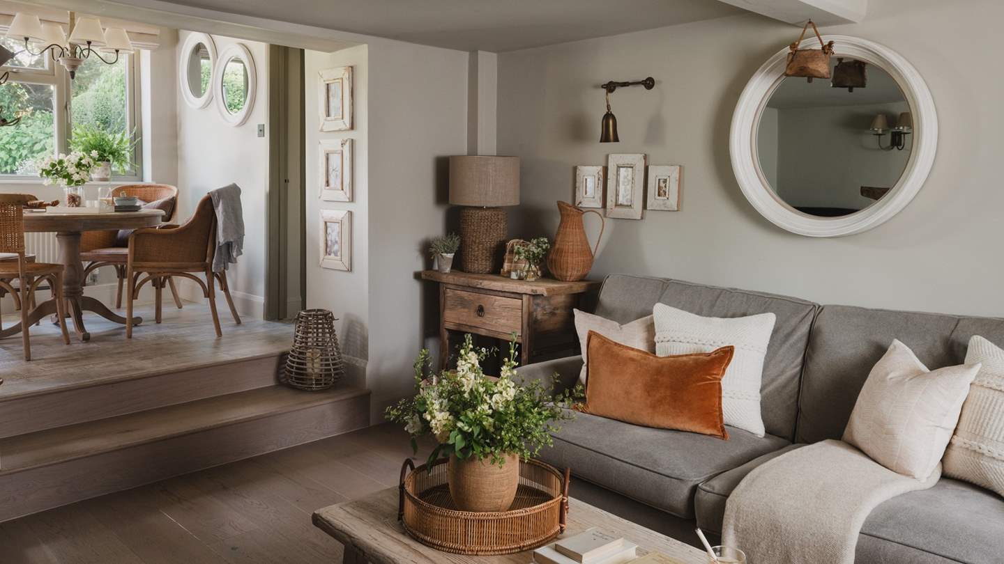 Steps lead from the lounge into the darling breakfast room, with a rustic table and rattan chairs for four

