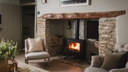A handsome wood burning stove rests proudly within a large inglenook fireplace for snug moments spent fireside