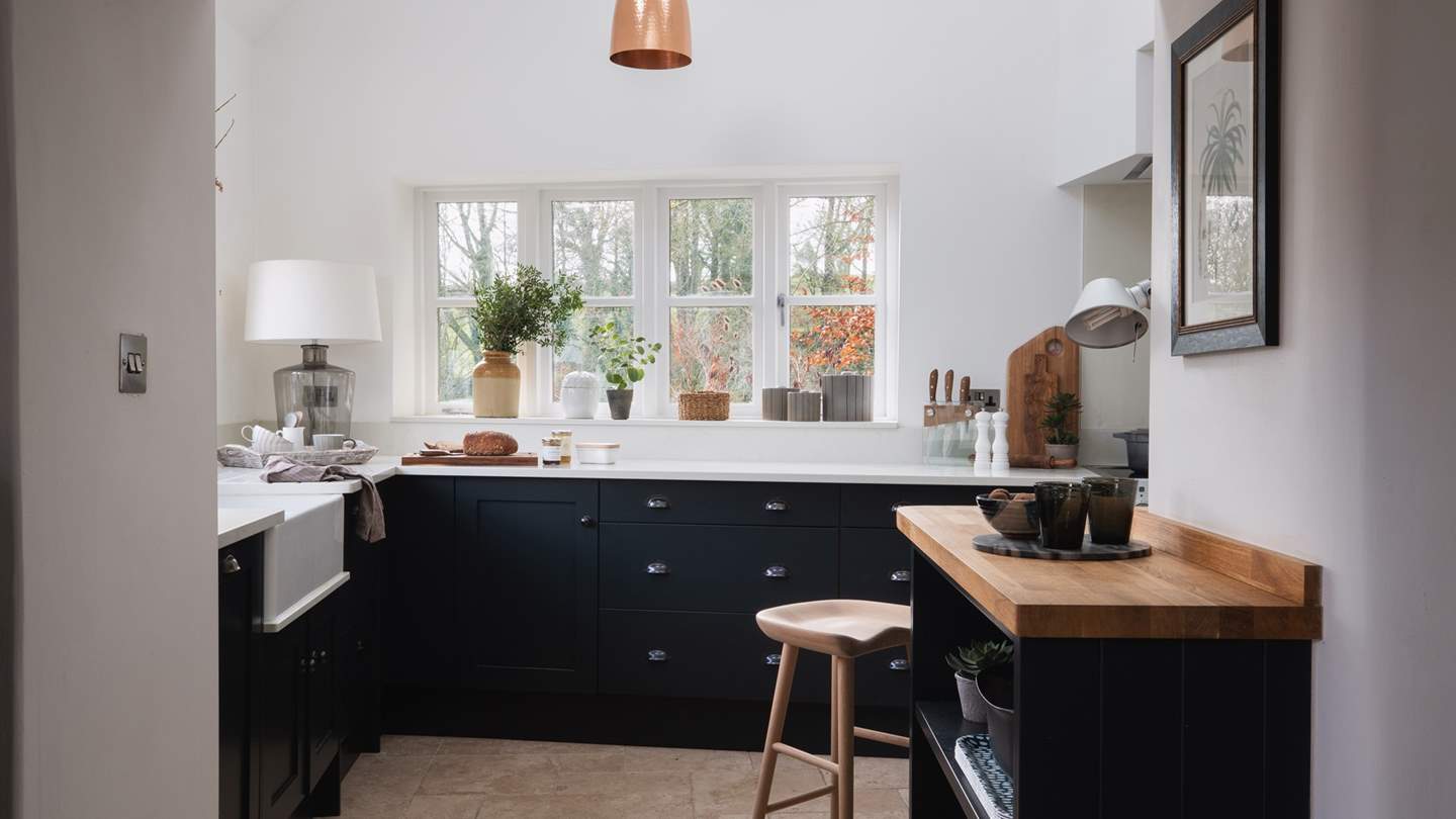 With a bright and airy colour palette contrasted with charcoal-coloured units and splashes of green from the garden-view windows, it’s a real dream