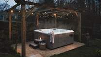 Set beneath a wooden pergola strung with fairy-lights, the dreamy hot tub provides a serene spot to sit back and unwind beneath the stars...