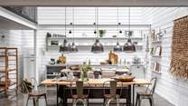 Wonderfully spacious, the open-plan, double-height living area at The Grey Shed encompasses a lounge, kitchen, and dining space
