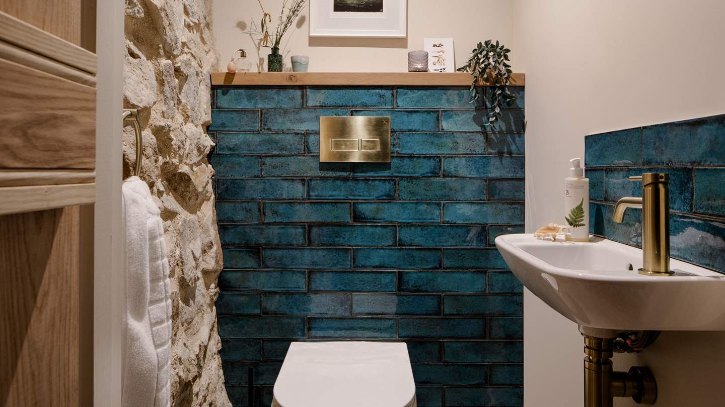 We love the cerulean tiles and brass finishing touches in the cloakroom toilet 