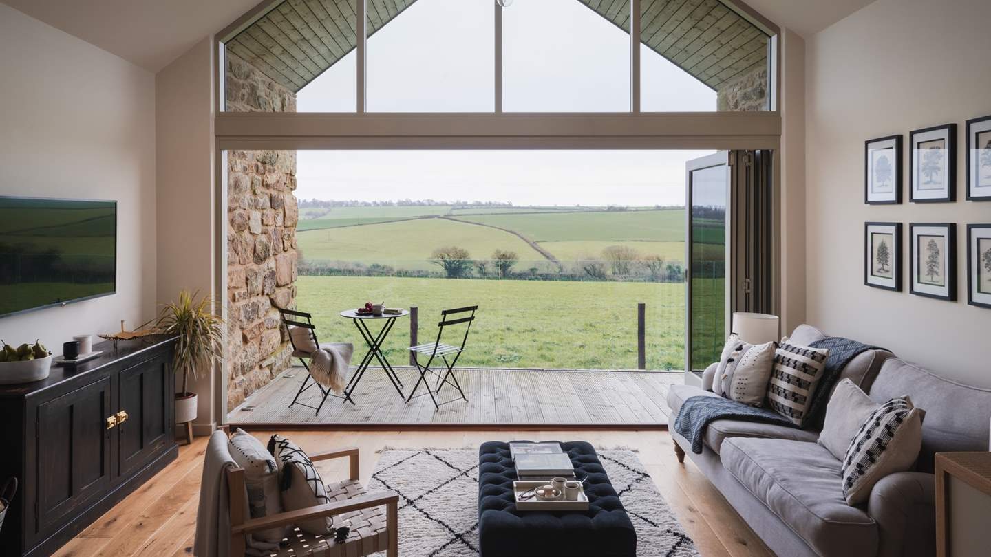 Drenched in light from the ceiling-high windows and glass concertina doors, and rejoicing in a subtle swathe of soft hues, the living room radiates tranquillity