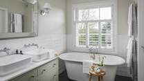 A lovely en suite with a large shower, freestanding bath and twin vanity basins