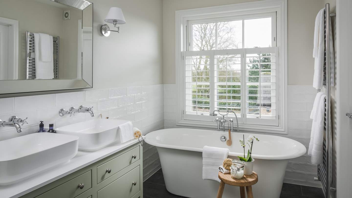 A lovely en suite with a large shower, freestanding bath and twin vanity basins