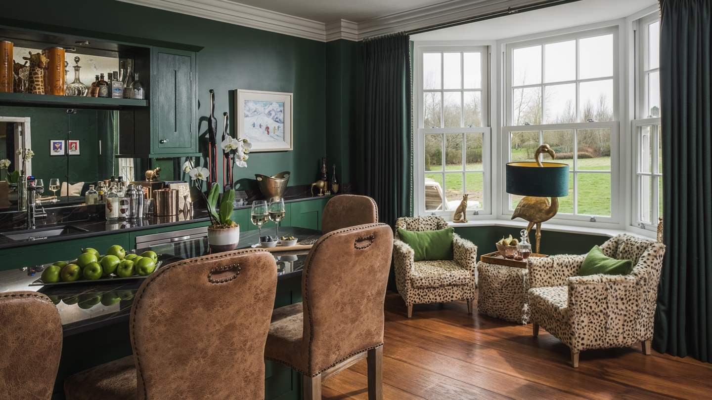 Featuring a sofa, four armchairs, large garden-view windows and a well-stocked bar