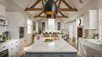 The heart of the home, the bright and airy kitchen and family room has a contemporary farmhouse feel, with a striking vaulted ceiling with open oak rafters and doors to the garden