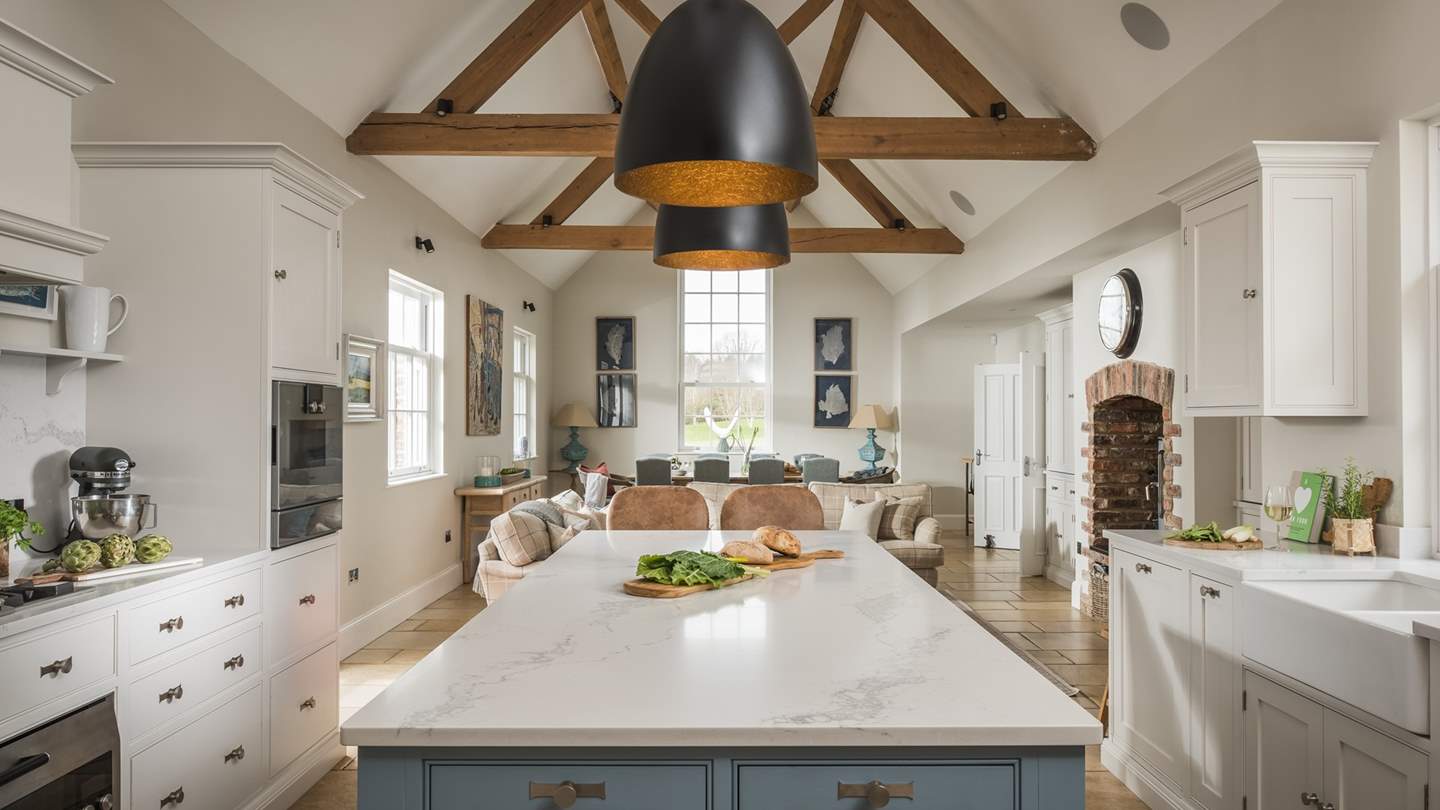 The heart of the home, the bright and airy kitchen and family room has a contemporary farmhouse feel, with a striking vaulted ceiling with open oak rafters and doors to the garden
