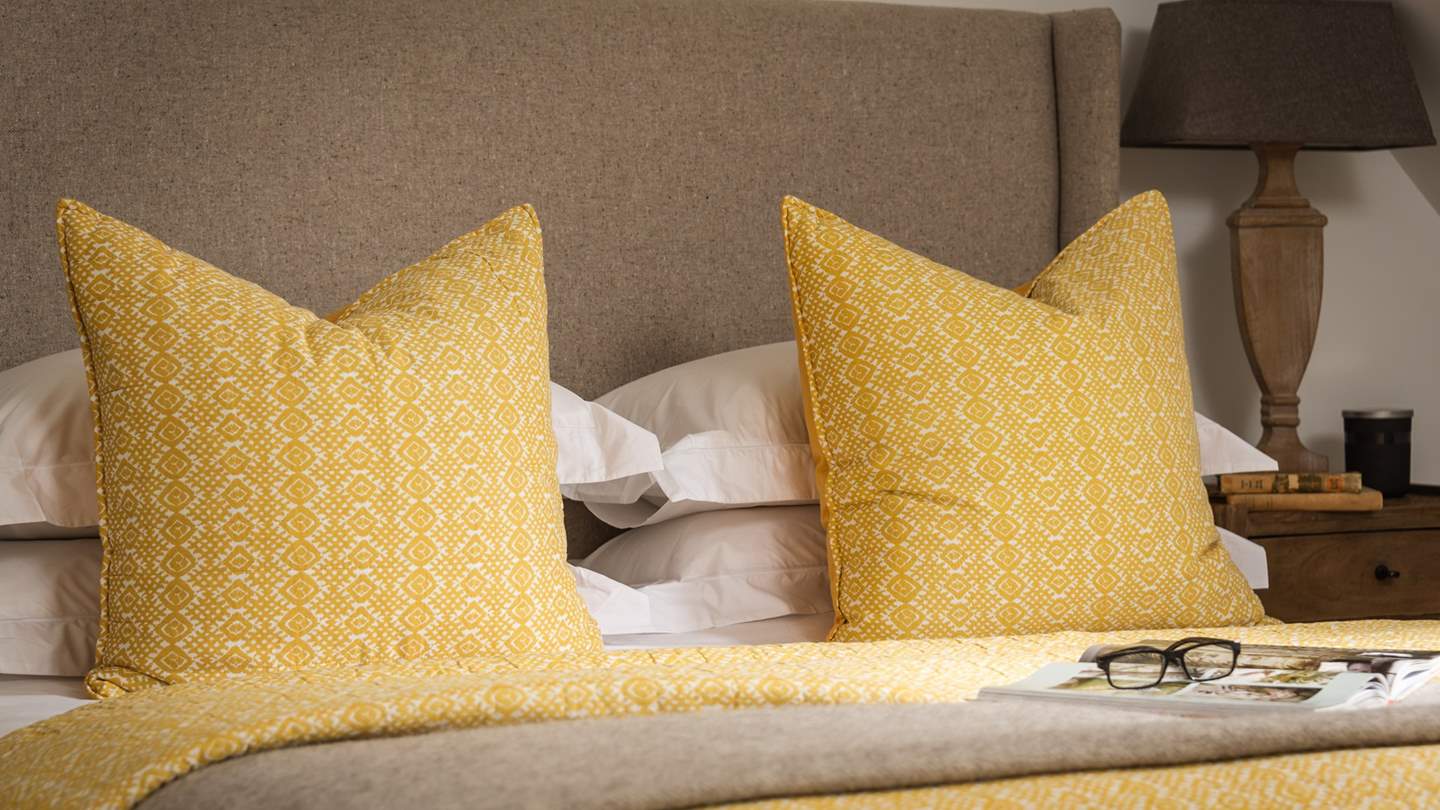 For somewhere to perch your book or your coffee, the bed is embraced by bedside tables, while built-in wardrobes and a chest of drawers provide ample storage