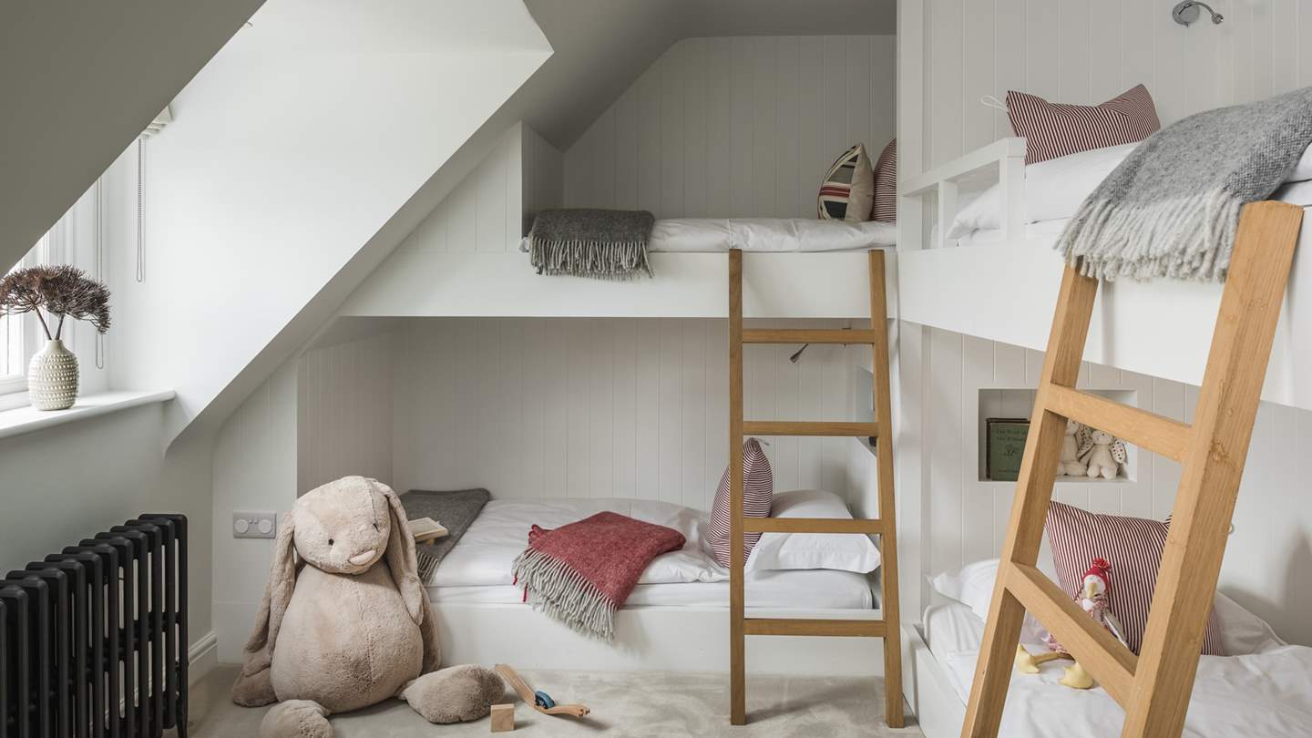 A real haven for children, bedroom seven boasts four built-in single bunk beds, as well as a cute cot bed in the folly room