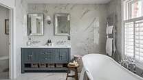 The en suite bathroom, where twin vanity basins, a twin shower and freestanding bath reside