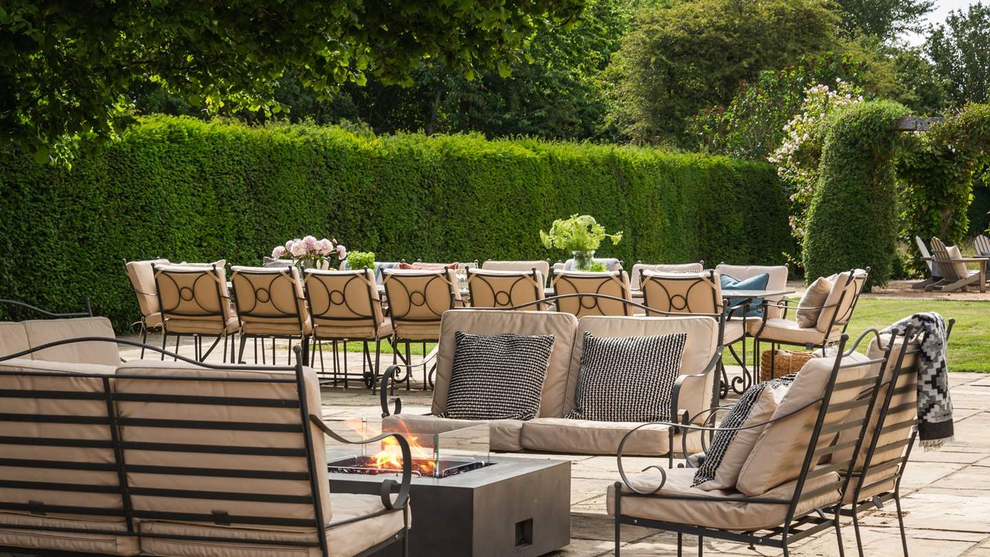 A medley of outdoor sofas and chairs nestle around a fire pit