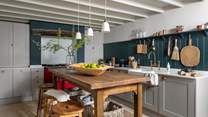 With teal wood panelling and a contrasting cherry-red AGA, this is an inspiring space for budding chefs...