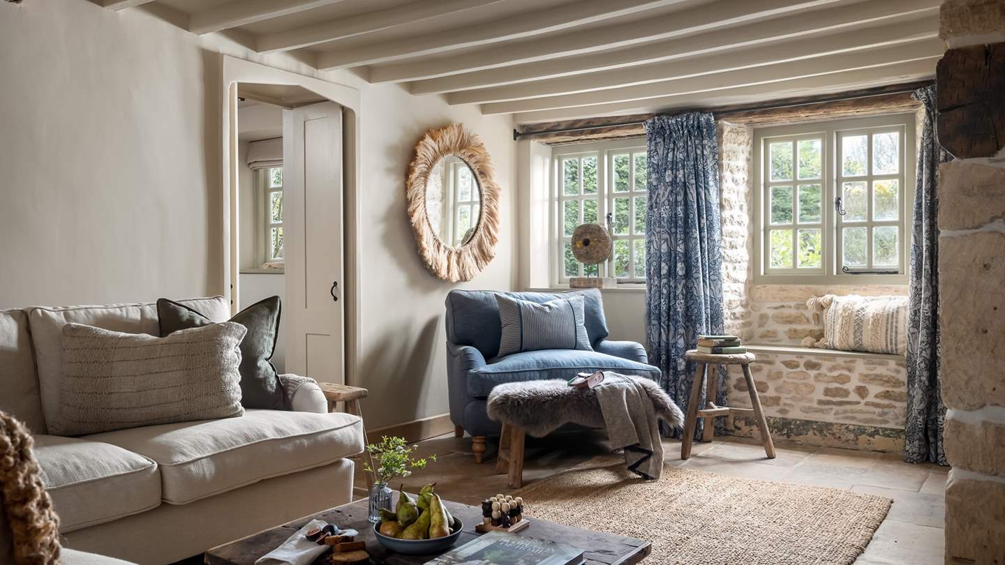 In the living room, a plump cream sofa and sumptuous blue loveseat await for evenings huddled in front of the Smart TV with a film