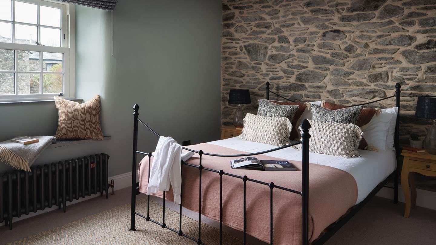 Soft sage and taupe tones create a soothing palate in bedroom three, complete with a king-size bed