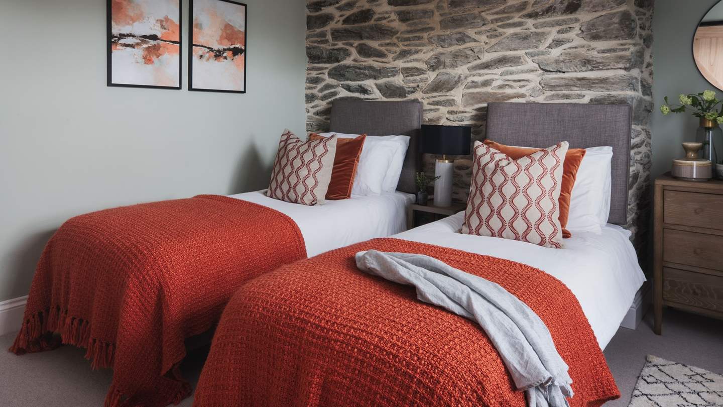 Decorated with burnt orange cushions and throws for warmth and benefiting from a chest of drawers, bedside table and hanging space for clothes, it beckons for pure relaxation