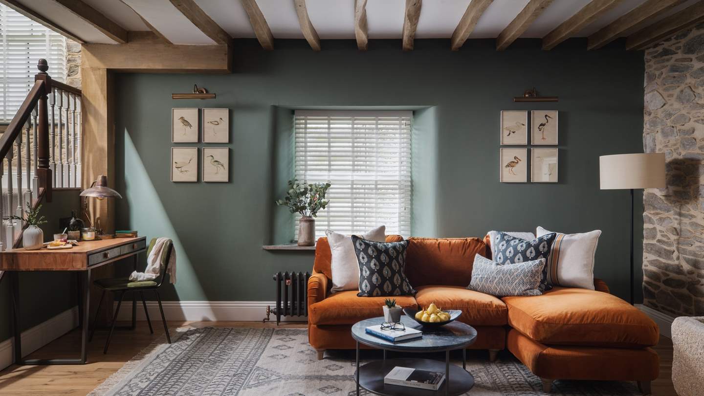 A homely space, an open snug with a burnt orange Loaf sofa and a Tikamoon desk sets the scene for peaceful repose