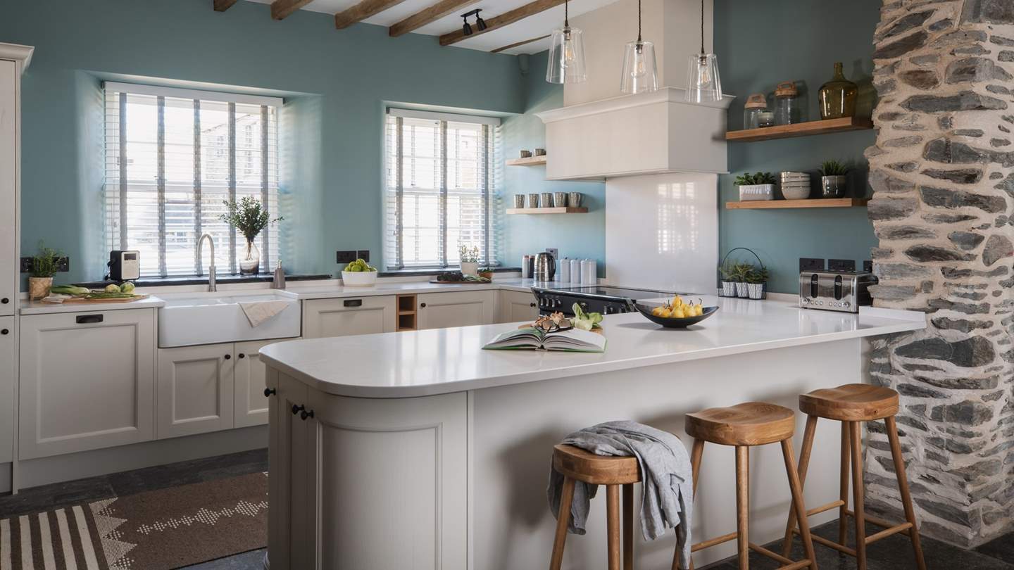 For leisurely breakfasts, gather around the stylish kitchen island with quartz worktop and take a pew on one of the trio of comfortable oak stools