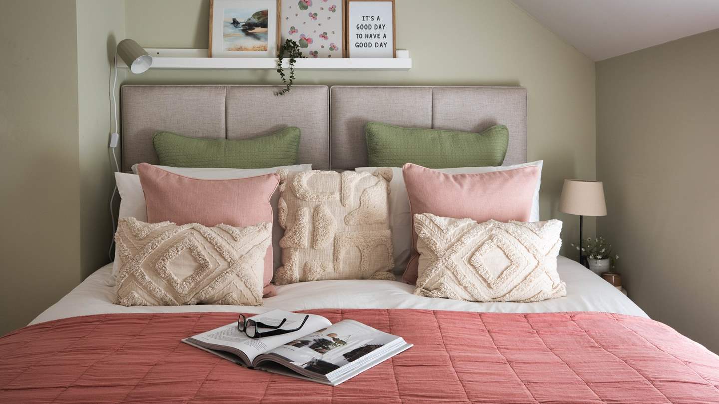 Full of period charm, it features tall, sloping ceilings and a low alcove window that looks out onto tufted fields and leafy trees