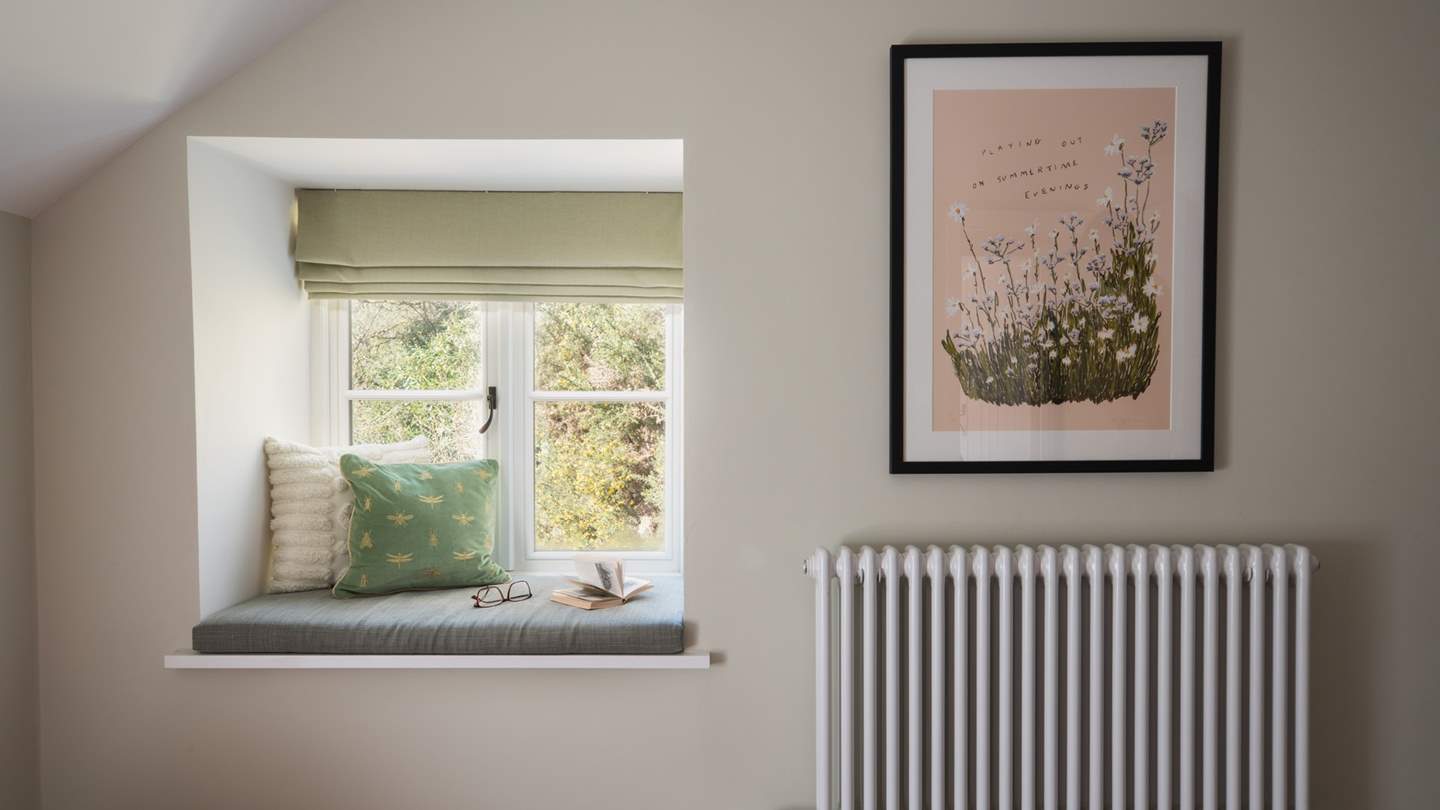 You'll find a sweet window seat, perfectly positioned to enjoy moments of calm as you gaze at the verdant scenery 