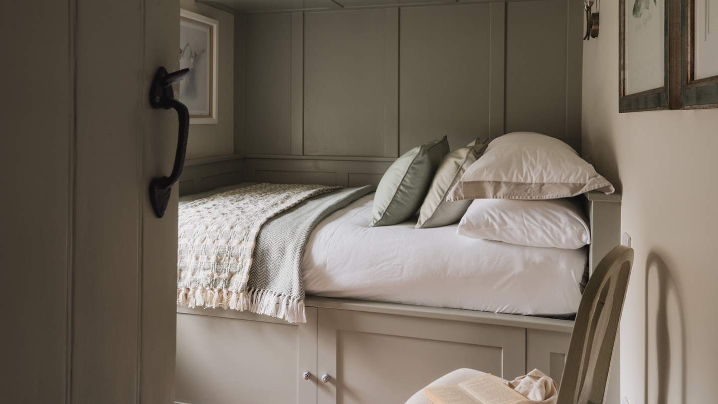 The darling double bed is settled within a snug cladded alcove 