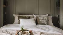 The master bed is dressed in complementary cushions and throws to evoke the most soothing slumbers