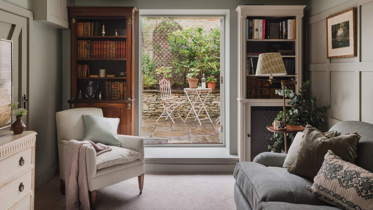 At the far side of the room, French doors open onto the paved patio, welcoming the outside in on balmy summer days