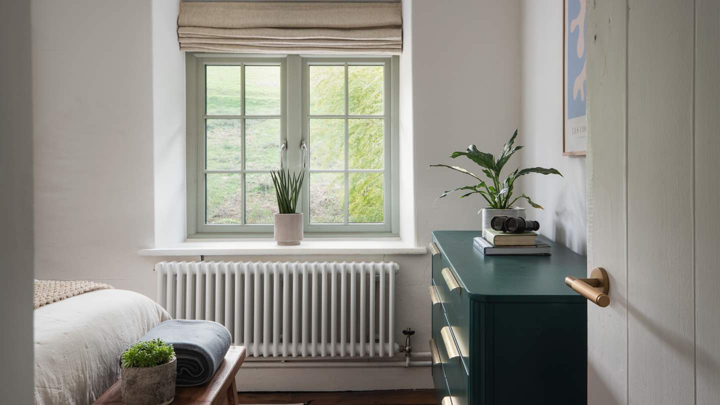 Dressed with olive-green inflections, this room also has an antique, teal-toned chest of drawers 