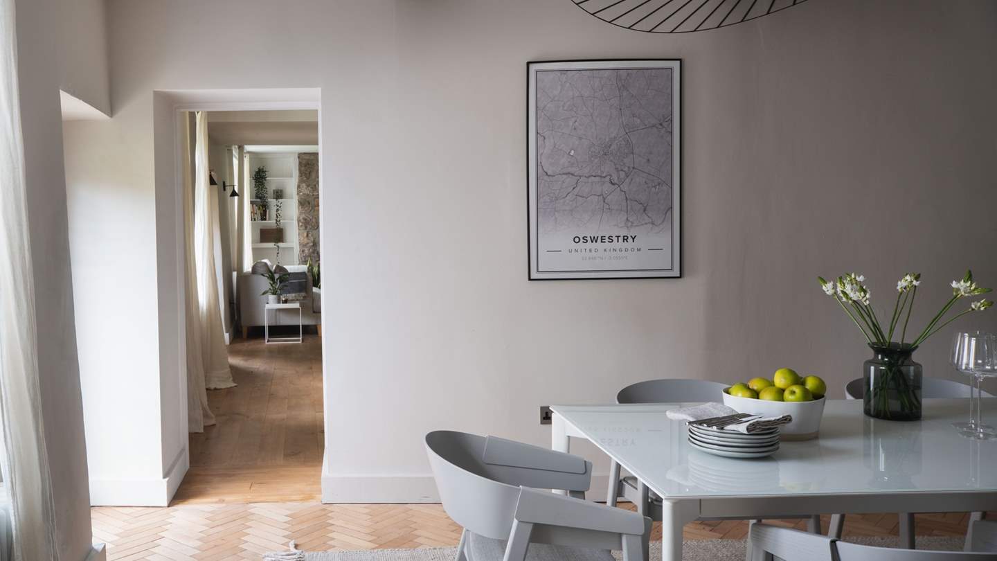 Through the hall, discover the formal dining room with an extending table resting under rustic beams...