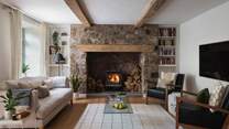 At the very end of the retreat lies the snug, where a second wood burning stove rests centre of an original stone fireplace