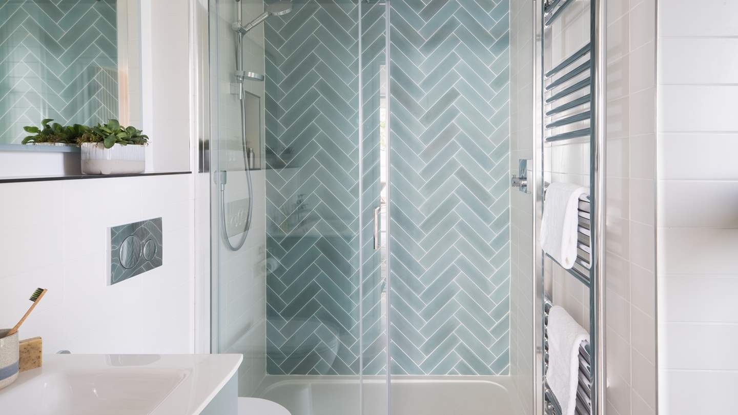 A large shower with teal parquet tiling can be found in the ensuite, with a rainfall shower head for wake-me-up mornings